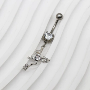 Détail macro du piercing nombril ailes de cœur argenté avec zircons transparents