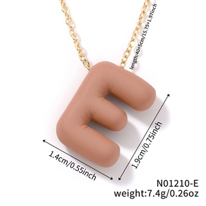 Detail showing matte letter E pendant dimensions 1.9cm by 1.4cm on a gold chain