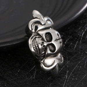 Gothic punk style stainless steel skull ring with crown detailing on textured background