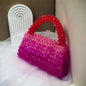 Detail of handmade beaded handbag showing red, pink and purple gradient beads
