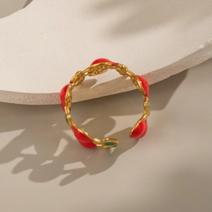 Detail of gold fruit ring featuring red cherries and green leaves on adjustable band