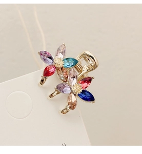 Macro shot of colorful crystal flower hair clip with sparkling rhinestones on gold base