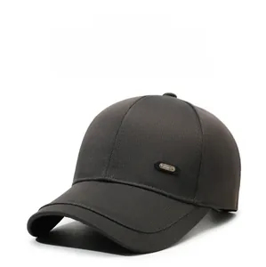 Detail view of sport metal emblem on side of dark brown cotton twill baseball cap