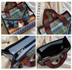 Detail of woven ethnic tote bag featuring colorful geometric patterns and decorative tassels