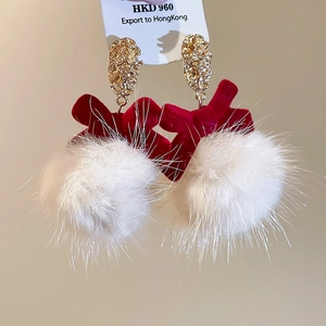 Detail of velvet bow earrings with fluffy white fur balls and golden metallic studs