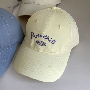 Close-up of cream cotton baseball cap with purple Paris chill RADIO embroidery detail
