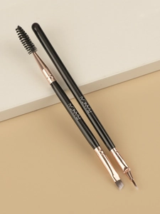 Detailed view of dual-ended eyebrow brush and fine eyeliner brush on a modern pedestal