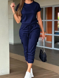 Detailed view of dark blue utility jumpsuit with drawstring waist and cargo side pockets