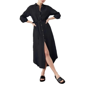 Dettaglio di abito a camicia nera a maniche lunghe con spacchi laterali e cintura coordinata