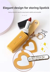 Macro detail of yellow pebble leather lipstick case with heart mirror and gold key ring