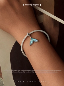 Detailed view of an S925 silver braided bracelet with a colorful fish tail pendant on wrist