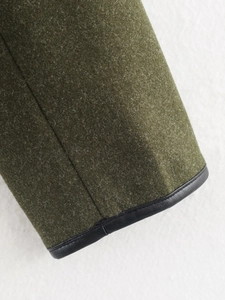 Detail of olive green woolen fabric texture with premium black PU leather bound edges