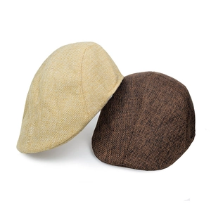 Detail view of beige and dark brown linen blend newsboy hats showing fabric texture