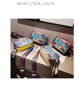 Detail of colorful graffiti camera bags in yellow and beige with wide woven straps