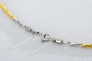 Vue macro d'une chaîne bicolore or et argent avec détails du fermoir mousqueton