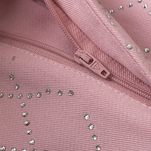 Détails macro de motifs strass Y2K roses et fermeture éclair sur pantalon en denim