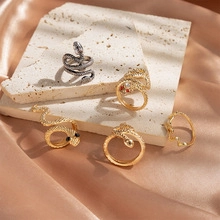 Detailed view of snake-shaped rings in gold and silver finish with scale textures