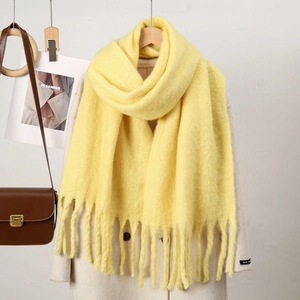 Détail de l'écharpe jaune en simili cachemire avec longues franges sur manteau beige