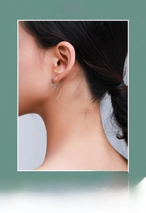 Close-up of minimalist S925 sterling silver earrings with abstract face line design
