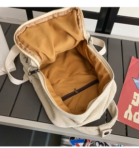 Innenansicht des beigen Cord-Rucksacks mit braunem Futter und Reißverschlusstasche