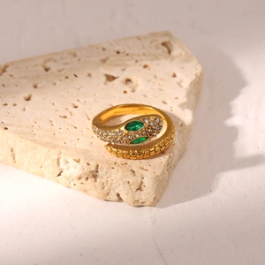 Macro view of 18K gold plated snake ring with green gem eyes and cubic zirconia
