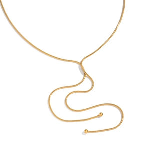 Détail du collier en Y chaîne serpent dorée avec pendentif sphère sur fond blanc
