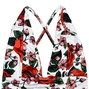 Detail of white summer dress showing deep V-neckline and red rose floral print pattern