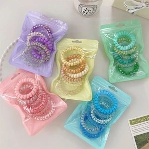Detail of spiral hair ties in colorful gradient sets and transparent packaging