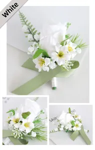 Detail of white artificial rose boutonniere with green leaves and ribbon for wedding