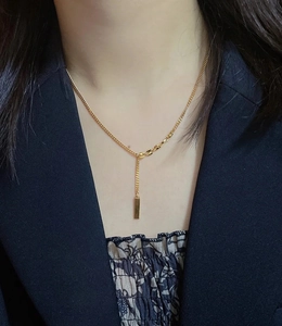 Minimalist gold bar pendant necklace in 18K plated titanium steel on female model