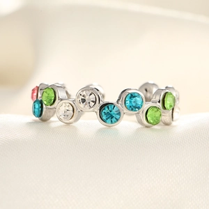 Macro view of silver adjustable ring with colorful pave zircons on white silk background