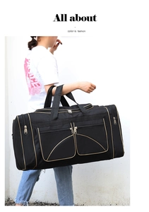 Model holding a large black nylon travel bag with gold zippers and side pockets