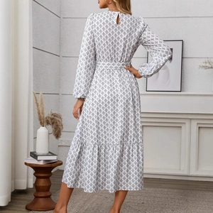 Detail of elegant white long sleeve dress with black geometric prints and belted waist