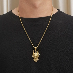 Close-up of a gold dragon head pendant with a braided chain on a male model neck