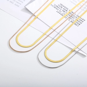 Detail of gold and silver snake bone chain necklaces showing different width textures