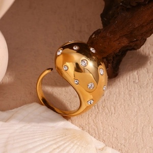 Macro shot of 18K gold plated wide ring with irregular hammered texture and inlaid crystals