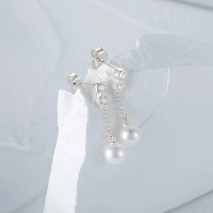 Macro view of S925 sterling silver stamp on earrings with pearls and cubic zirconia