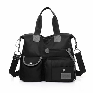 Detail view of durable black nylon travel bag with grey webbing handles and zipper accents