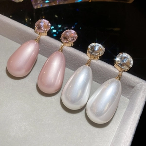 Macro shot of French vintage teardrop pearl earrings with sparkling round cubic zirconia gems