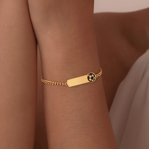 Detail of a gold stainless steel kid's bracelet with a plain plate and soccer ball charm