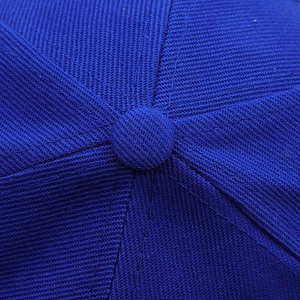 Close-up detail of royal blue twill fabric crown with button on top of baseball cap