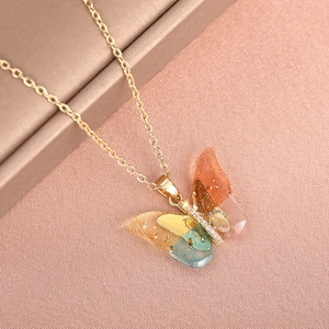 Macro shot of colorful butterfly pendant with gradient wings and gold foil details