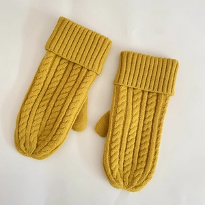 Close-up of bright yellow cable-knit mittens with warm fleece lining and thick wool texture
