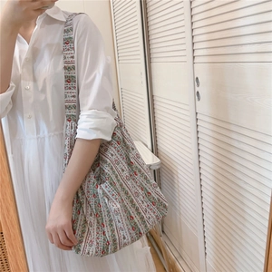 Détail du sac cabas en coton avec motif floral bohème vert et rouge sur tissu