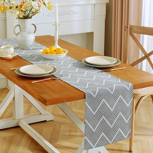 Close-up of Nordic grey wavy cotton linen table runner with elegant table setting decor