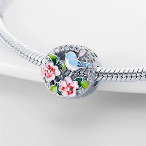 Abalorio de flor de plata con pájaros de esmalte rosa y circonitas en pulsera