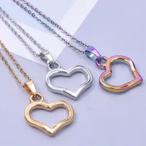 Three hollow heart necklaces in gold, silver and rainbow plating on a gray background