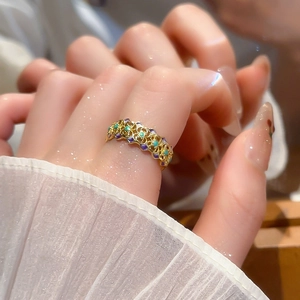 Close-up of 18k gold plated vintage ring with green and purple enamel floral patterns