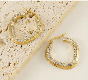 Macro view of 18K gold plated earrings with crystal inlay and Greek key pattern