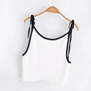 Mini-robe en tricot blanc avec bordure contrastée noire et bretelles réglables sur cintre